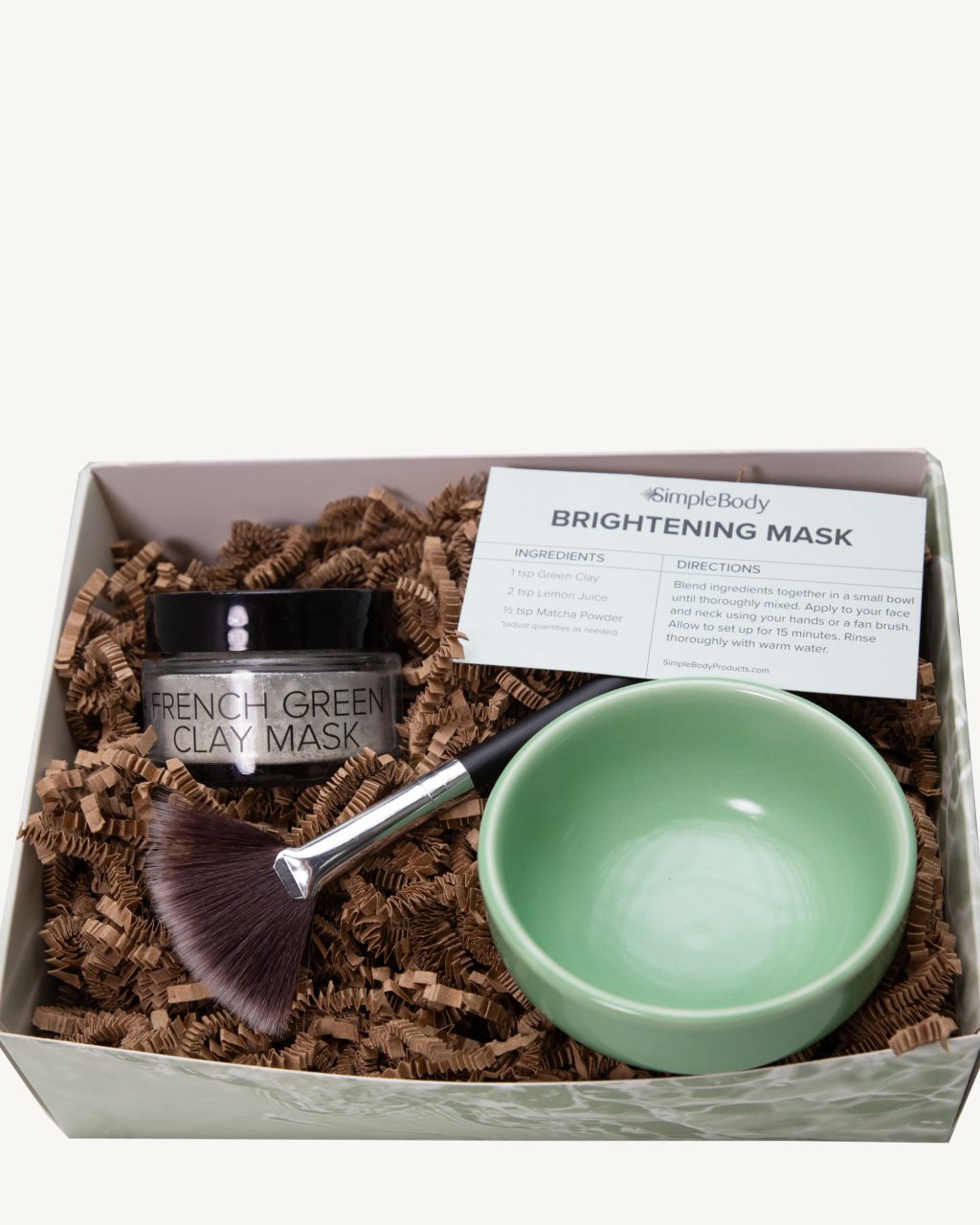 A photo of a clay mask kit including a Simple Body Green Clay Mask, Fan Brush, Green Pinch Bowl and a recipe card in a beautiful gift box
